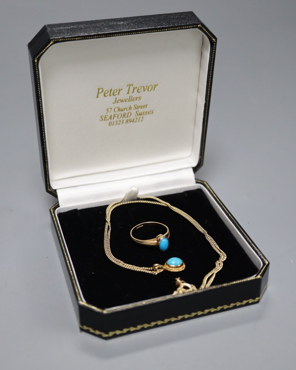A cabochon turquoise-set oval pendant on 9ct gold fine chain and a similarly-set 9ct gold ring, gross 5.4 grams.